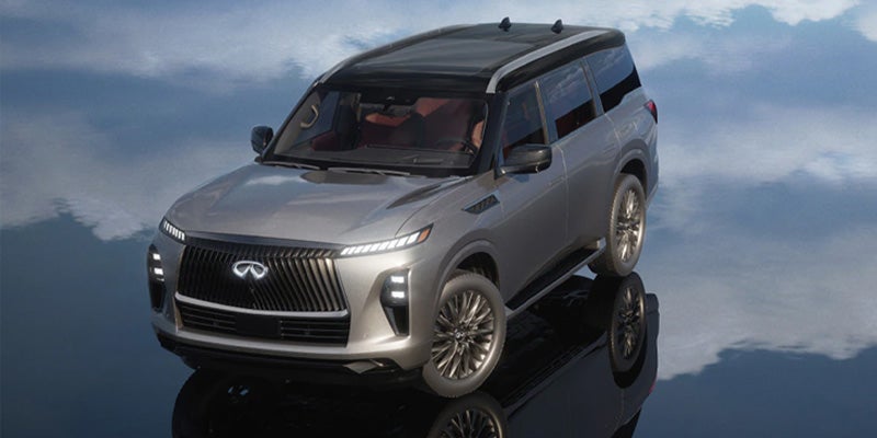 Silver Infiniti QX80 SUV in a high-angle studio shot, reflecting on a polished surface.
