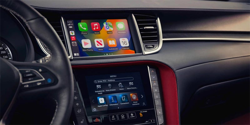 
Close-up of an Infiniti dashboard showing the dual infotainment screens with Apple CarPlay active.
